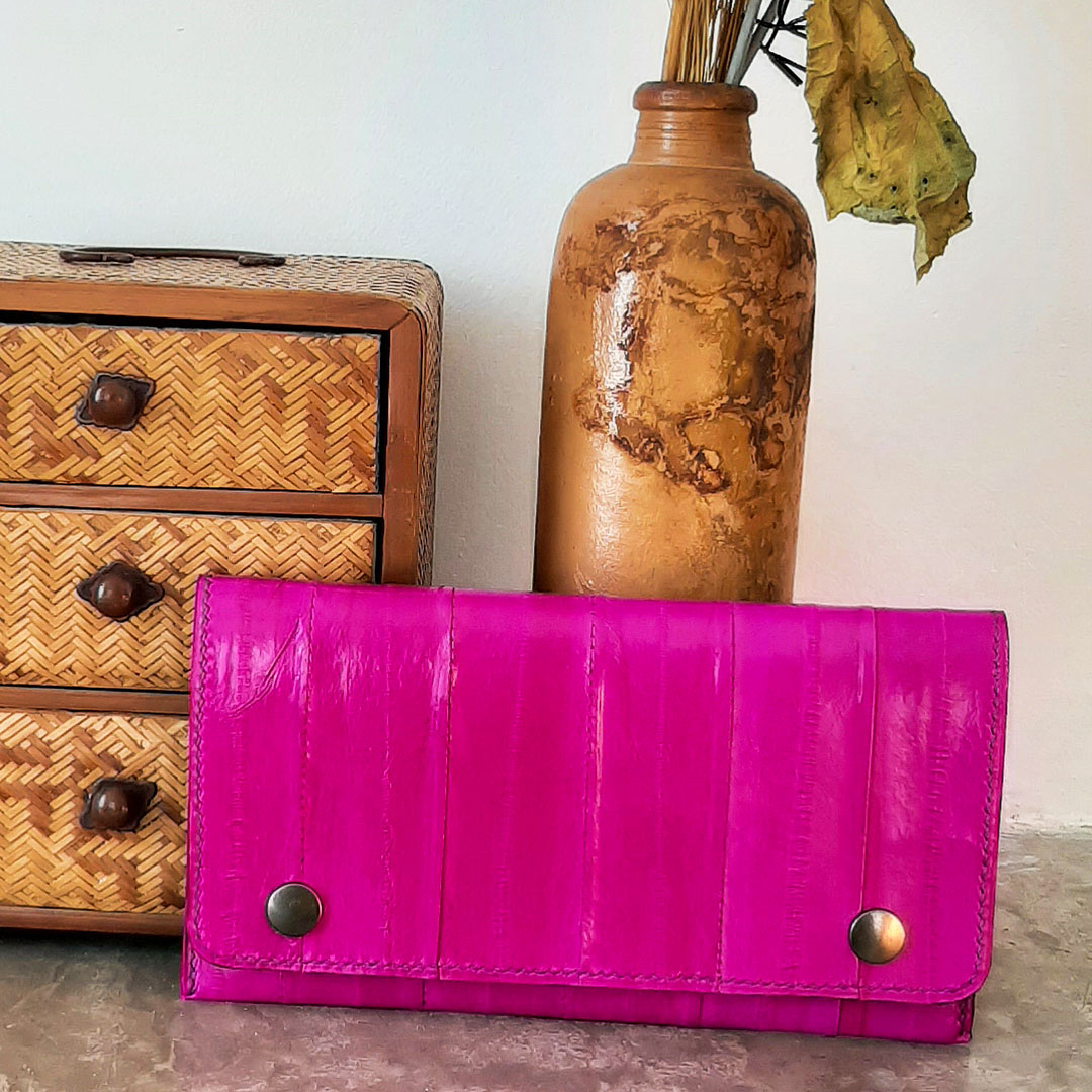 Vue de la pochette ou compagnon Carleine en cuir d'anguille de couleur fuchsia. Couture main au point sellier. 2 boutons pression doré.