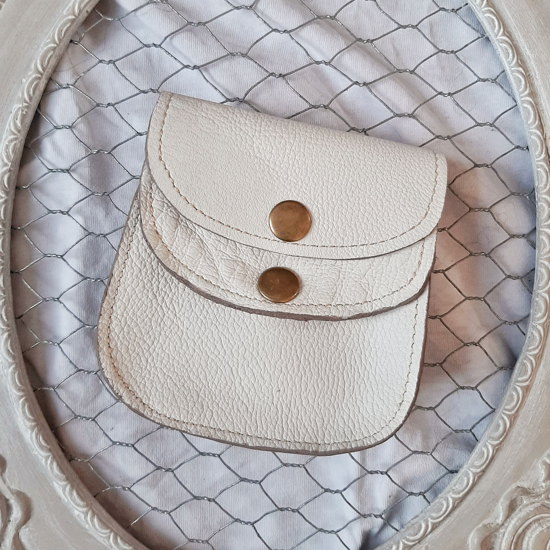 Porte monnaie à 2 compartiments. Se ferme avec 2 rabats par boutons pressions. Cuir grainé blanc. Intérieur brut
