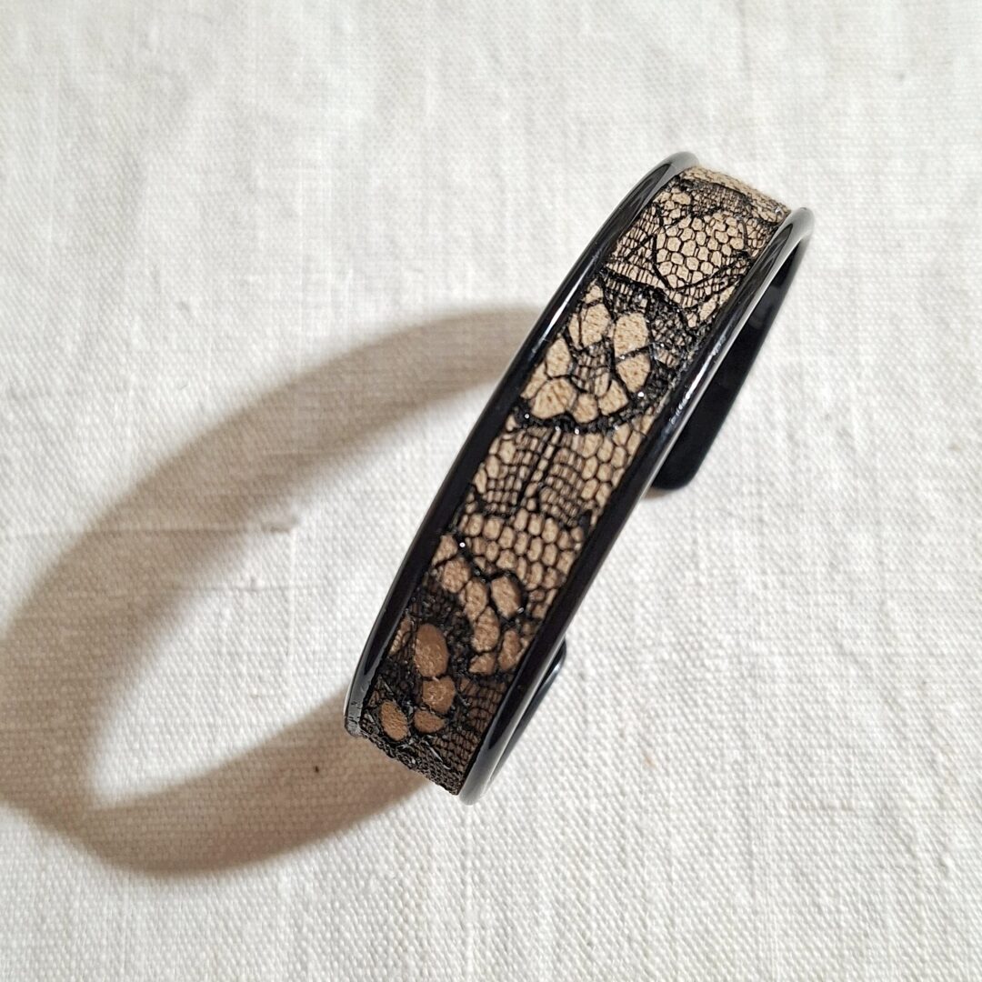 bracelet manchette en métal noir et cuir application d'une dentelle noire. Le bracelet est réglable à votre poignet. Pièce unique