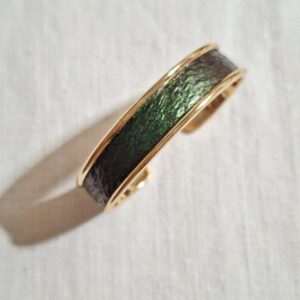 bracelet manchette en laiton doré avec cuir de saumon vert foncé aux reflets irisés.