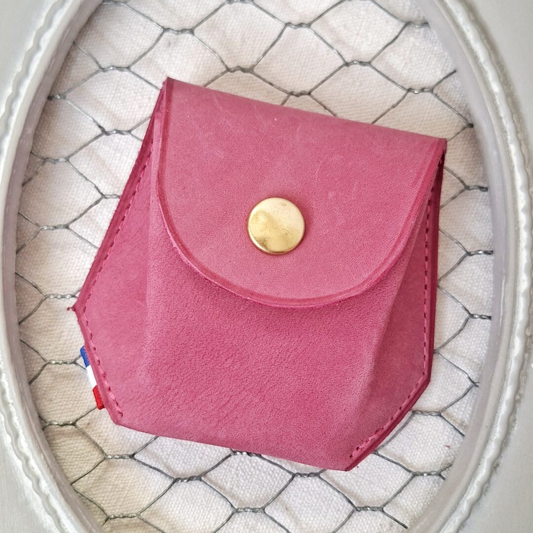 Porte-monnaie de forme hexagonale réalisé dans du cuir rose tannage végétal toucher velours. Couture finition main, et fermeture par bouton pression doré.