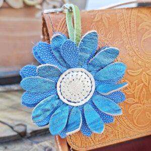 Porte-clés fleur en cuir bleu avec pétales texturés et cœur clair cousu à la main