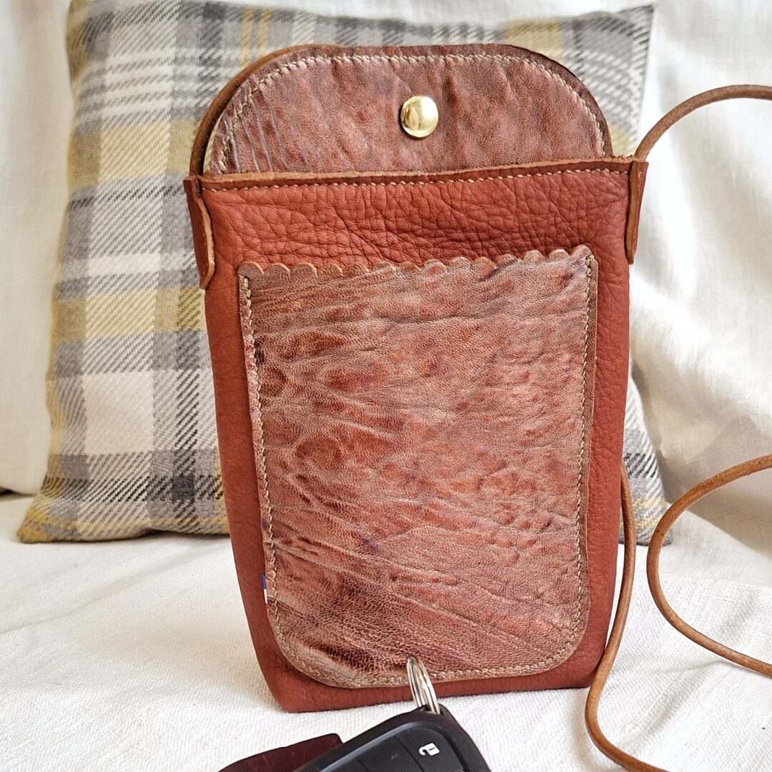 Pochette téléphone artisanale marron en cuir pleine fleur avec poche avant en cuir de chèvre brillant.