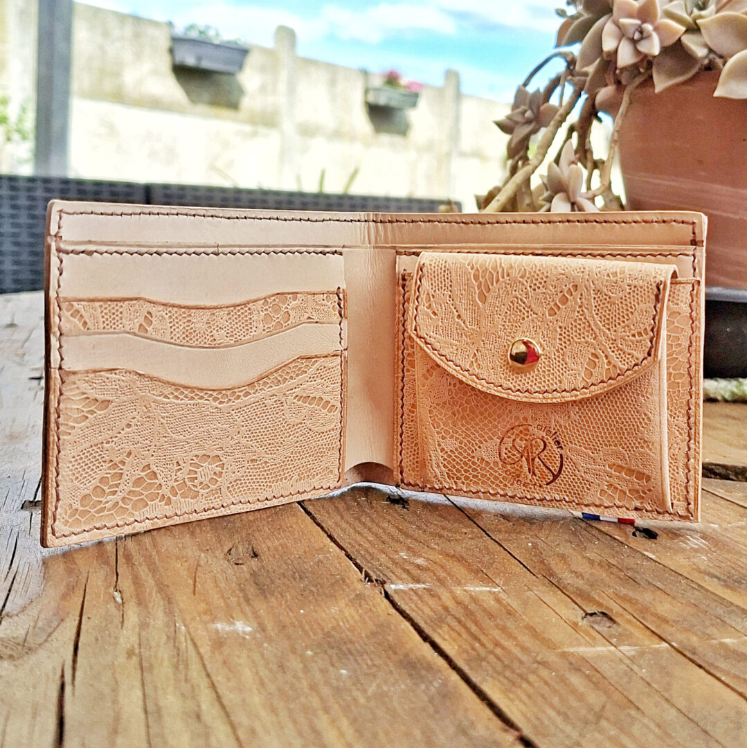 Portefeuille en cuir tannage végétal embossé dentelle ouvert montrant les rangements pour cartes et le porte-monnaie intégré
