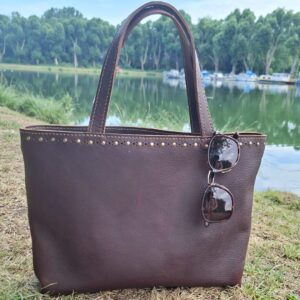 Cabas femme en cuir pleine fleur pull-up marron foncé avec lunettes de soleil, fabrication artisanale française.