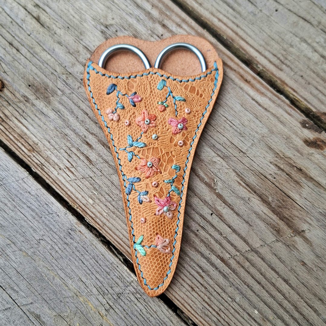 Étui à ciseaux de broderie en cuir tannage végétal embossé motif dentelle, brodé à la main de fleurs bleues et roses, avec ciseaux assortis